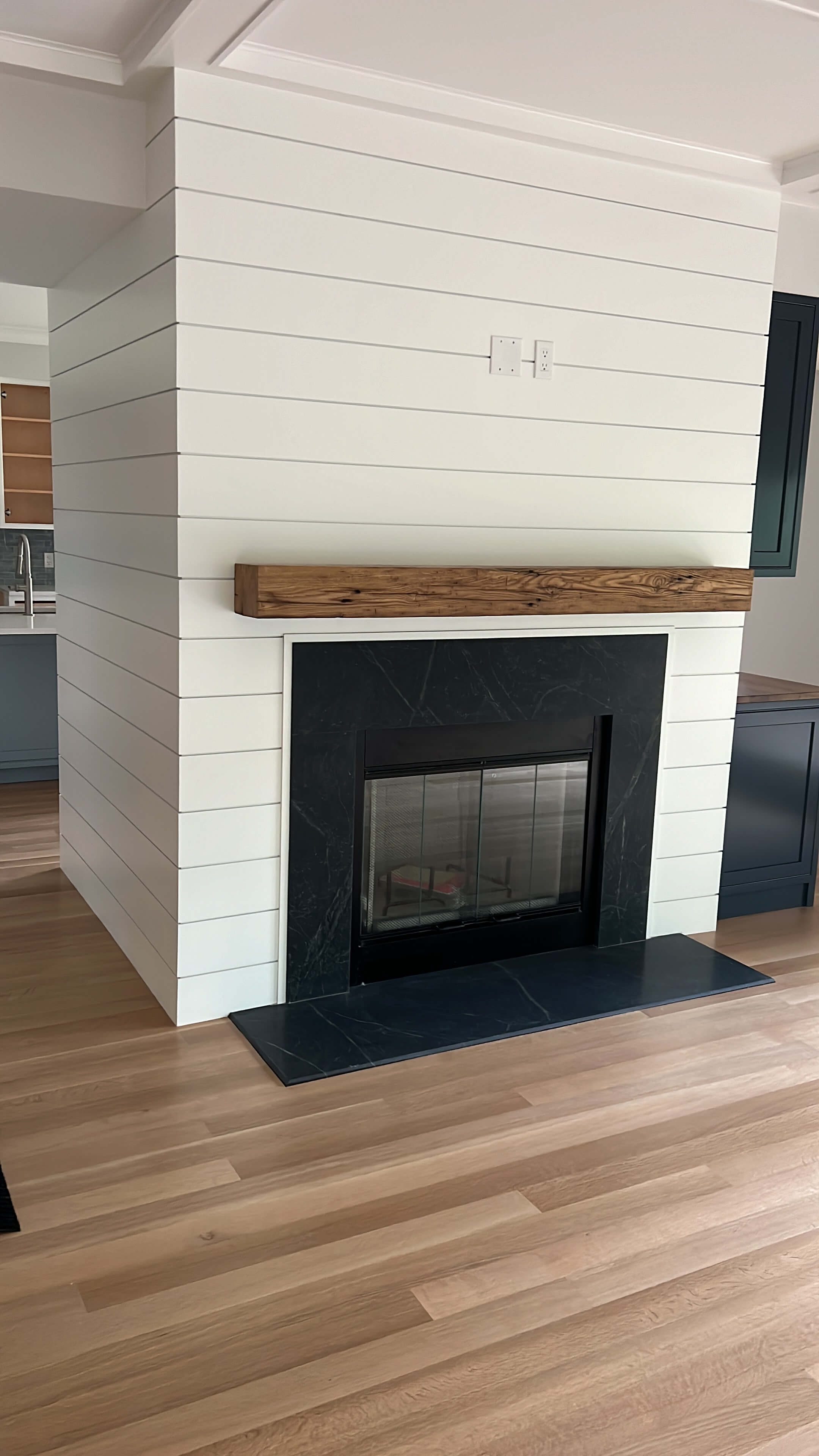 Shiplap fireplace with reclaimed-wood mantel and soapstone surround